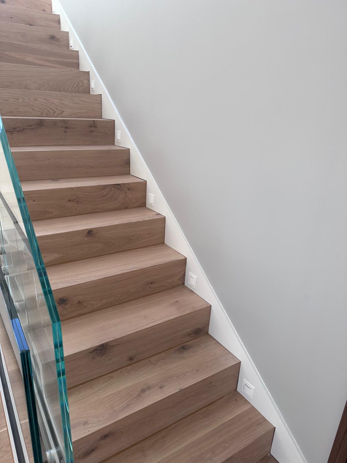 Escalier en chêne avec coupes d'onglet et garde-corps en verre