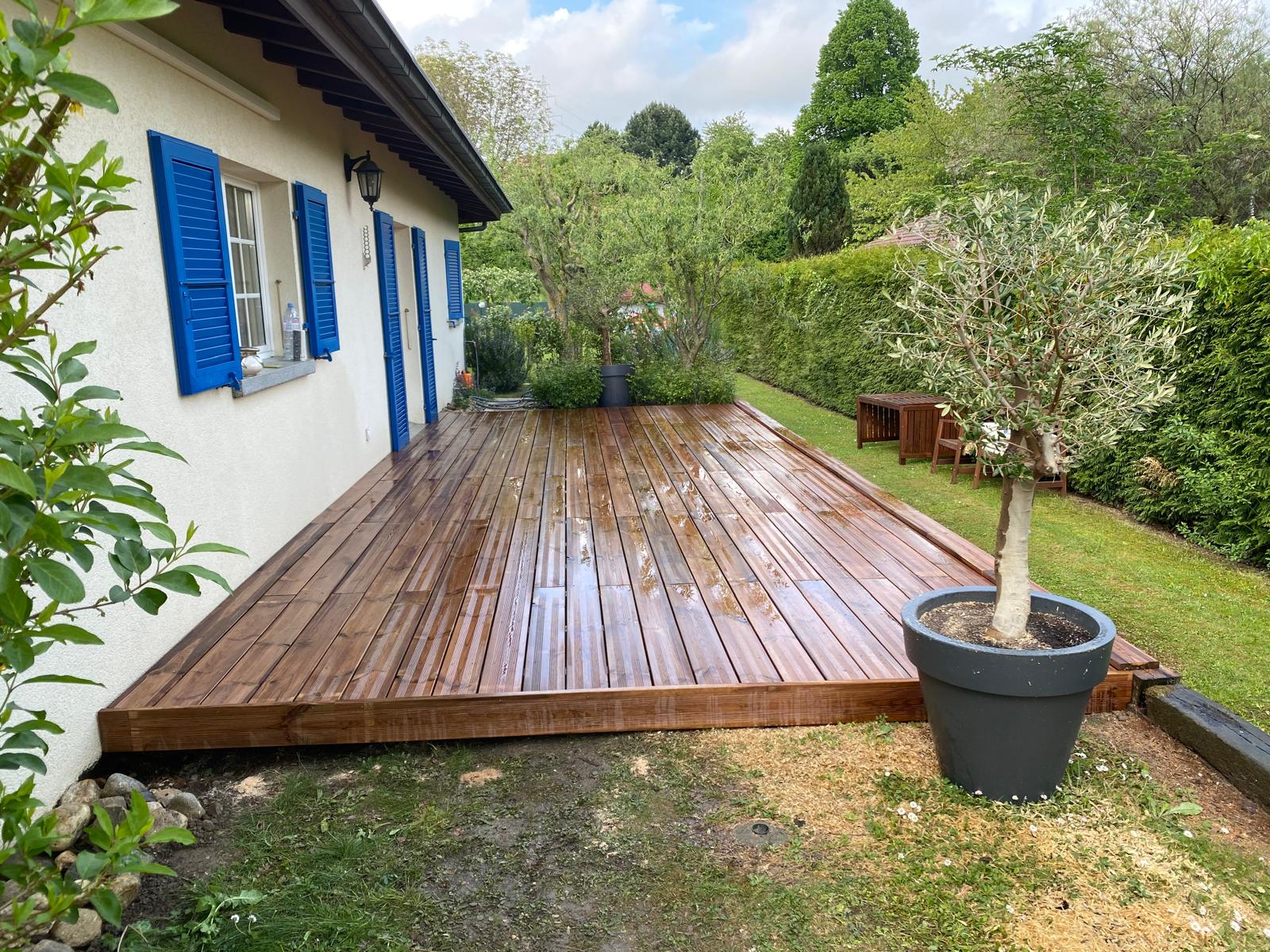 Terrasse en pin sur dalles béton avec bordure en poutres de train